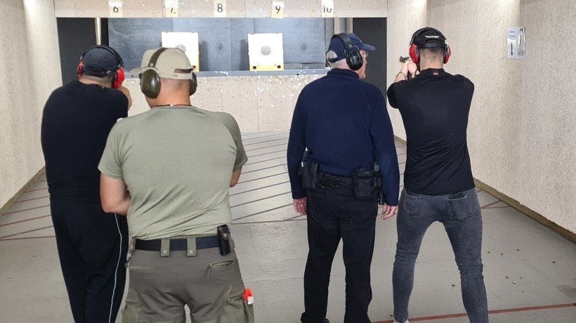 Teilnehmer eines Waffensachkundelehrgangs beim praktischen Schießtraining unter Aufsicht auf dem Schießstand